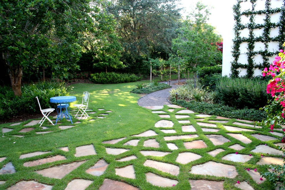 Modelo de jardín mediterráneo en patio trasero con adoquines de piedra natural