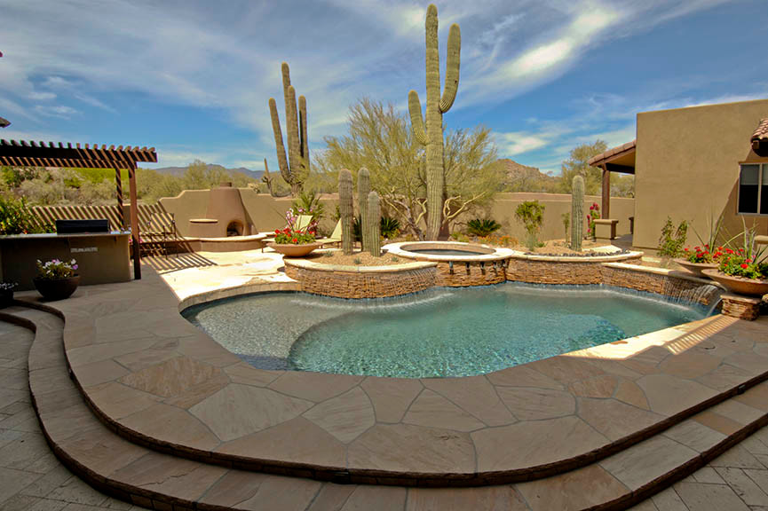 Diseño de piscinas y jacuzzis de estilo americano de tamaño medio en patio trasero con adoquines de piedra natural