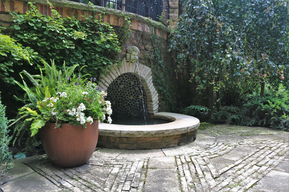 Cette image montre un petit jardin sur cour bohème l'été avec un bassin, une exposition partiellement ombragée et des pavés en pierre naturelle.