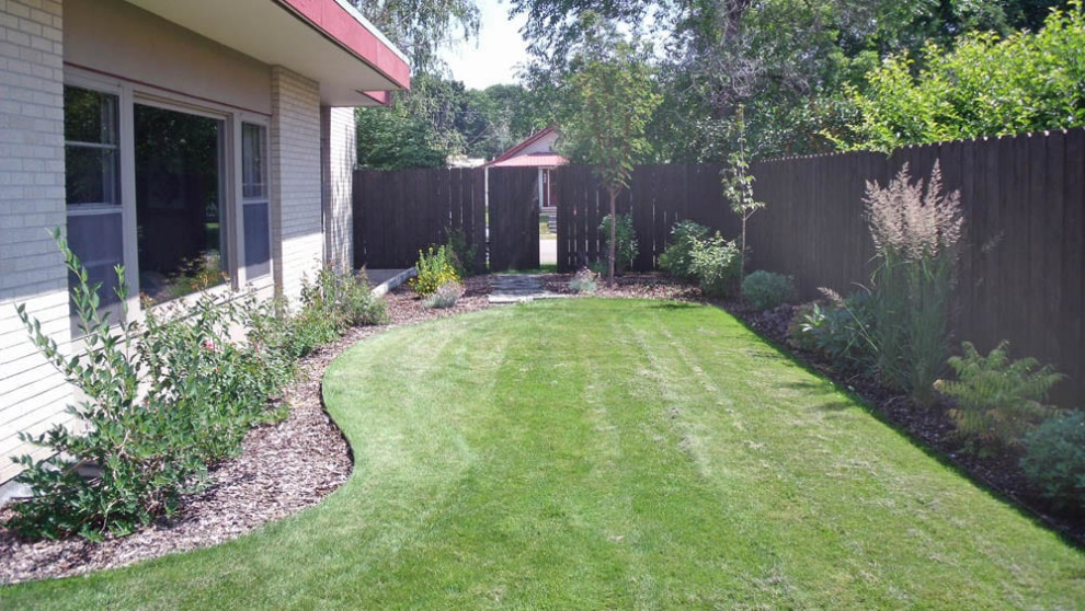 Photo of a mid-century modern side yard mulch landscaping in Other.