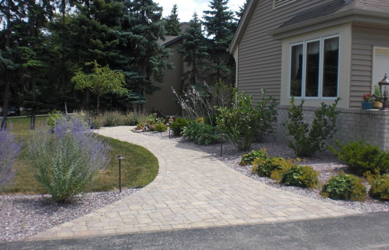 Exemple d'un aménagement d'entrée ou allée de jardin avant chic avec des pavés en pierre naturelle.