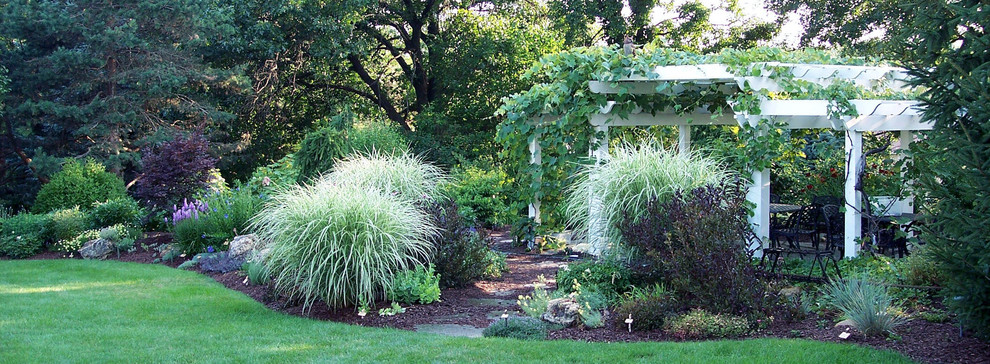 Immagine di un grande giardino chic esposto in pieno sole dietro casa con un ingresso o sentiero e pavimentazioni in pietra naturale