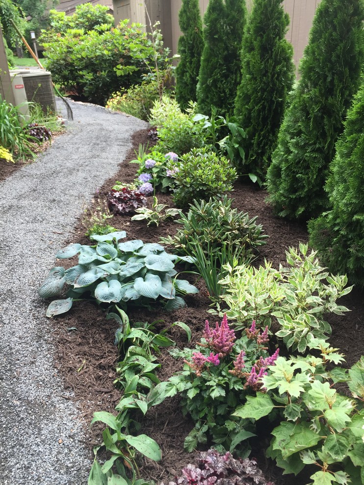 Kleiner, Halbschattiger Klassischer Garten im Sommer, neben dem Haus mit Mulch in Bridgeport