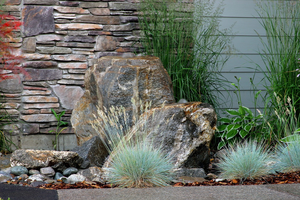 Modelo de jardín contemporáneo grande en patio trasero con jardín francés y adoquines de piedra natural