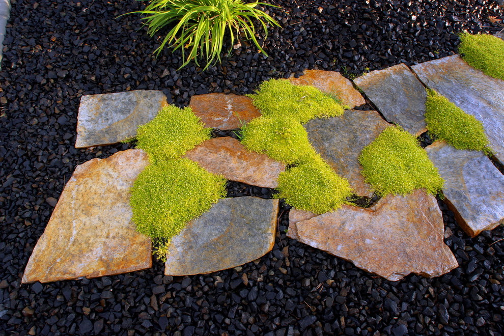 This is an example of a large contemporary backyard stone landscaping in Seattle.