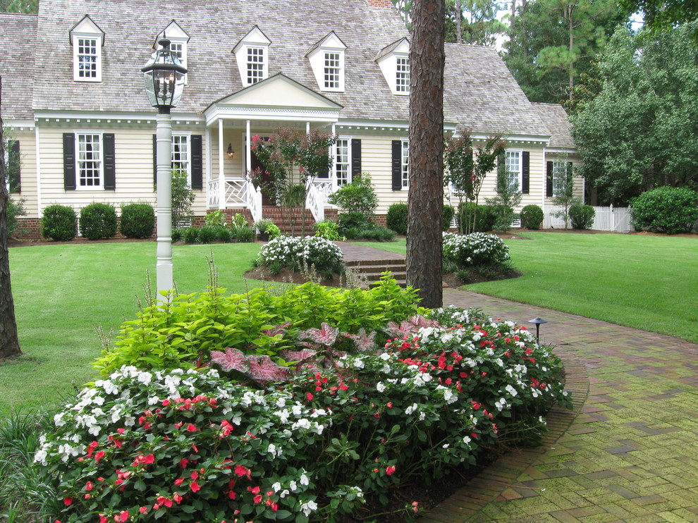 Foto di un grande giardino formale moderno esposto a mezz'ombra davanti casa in estate con pavimentazioni in mattoni