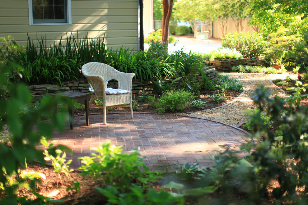 Foto de camino de jardín romántico de tamaño medio en primavera en patio trasero con exposición reducida al sol y adoquines de ladrillo