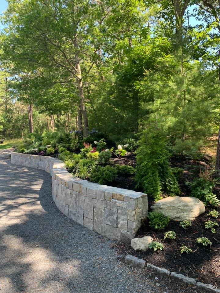 Photo of a large traditional shade backyard gravel retaining wall landscape in Boston.