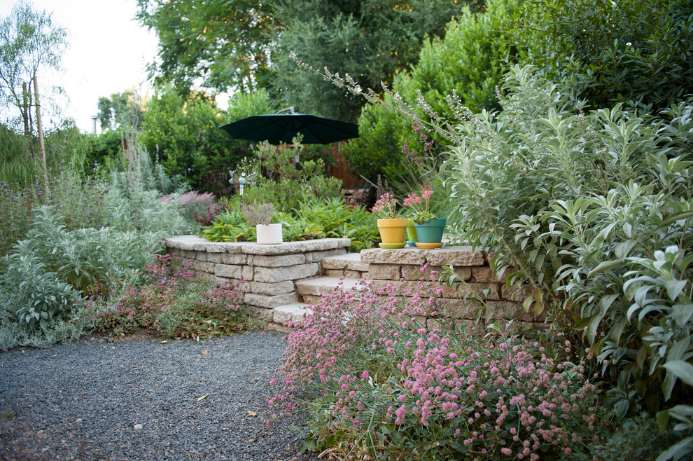 This is an example of a small rustic drought-tolerant and partial sun backyard concrete paver retaining wall landscape in Los Angeles for summer.