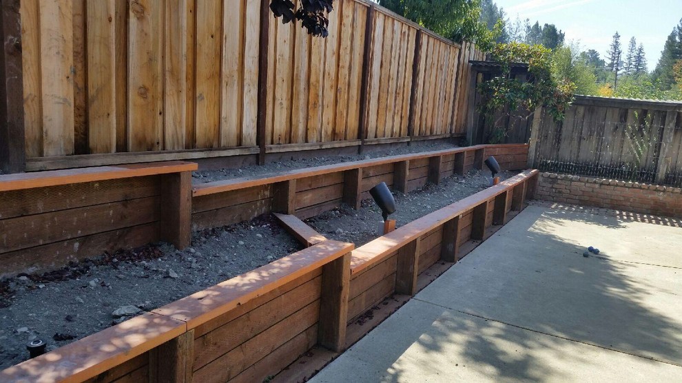 Photo of a mid-sized rustic full sun backyard concrete paver retaining wall landscape in San Francisco.