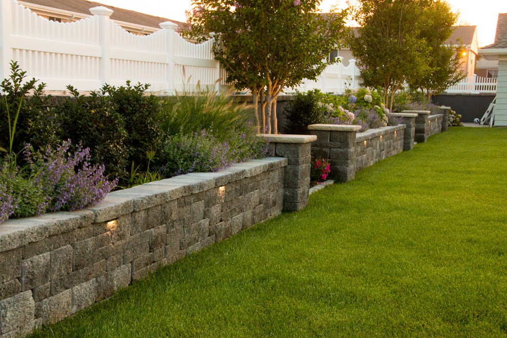 На фото: регулярный сад среднего размера на заднем дворе в классическом стиле с подпорной стенкой и покрытием из каменной брусчатки