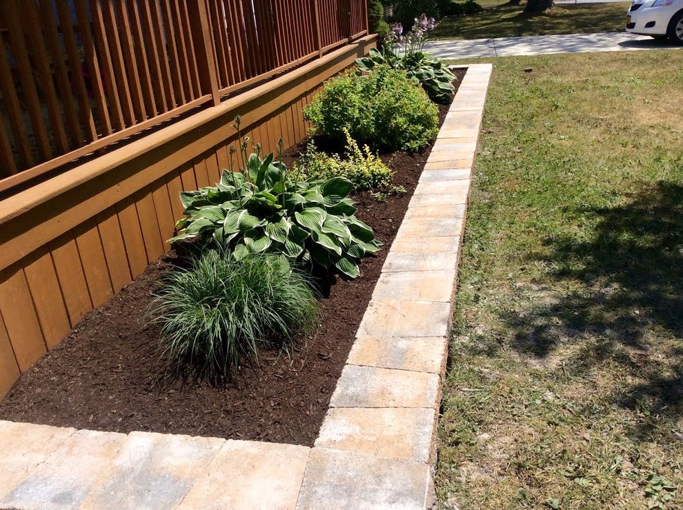 Photo of a small classic front full sun garden for summer in New York with concrete paving.