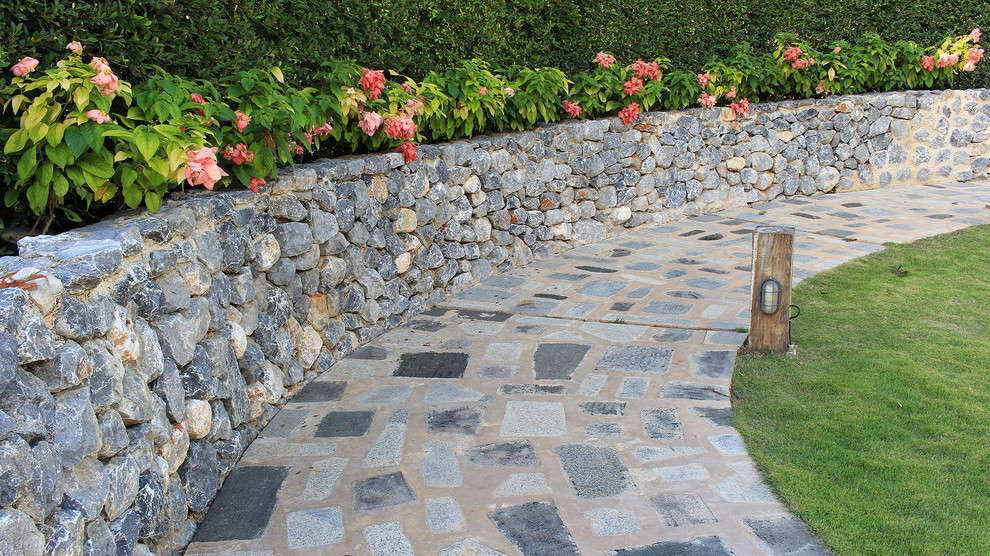 Inspiration pour un jardin à la française arrière traditionnel de taille moyenne avec un mur de soutènement et des pavés en pierre naturelle.
