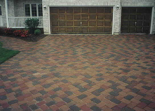 This is an example of a medium sized traditional front driveway full sun garden for summer in Indianapolis with brick paving.