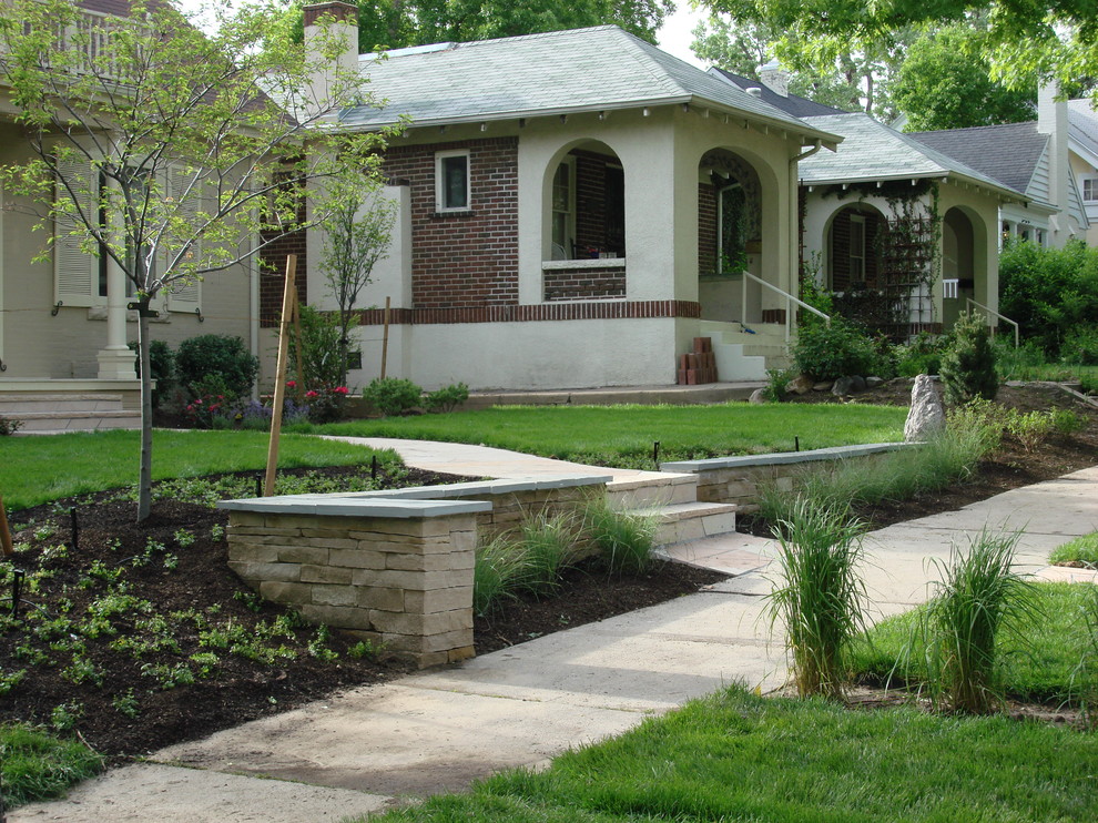 Foto di un giardino chic esposto a mezz'ombra di medie dimensioni e davanti casa con un muro di contenimento e pavimentazioni in pietra naturale