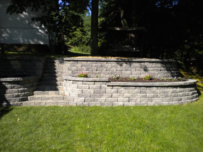This is an example of a mid-sized traditional partial sun front yard stone retaining wall landscape in St Louis.