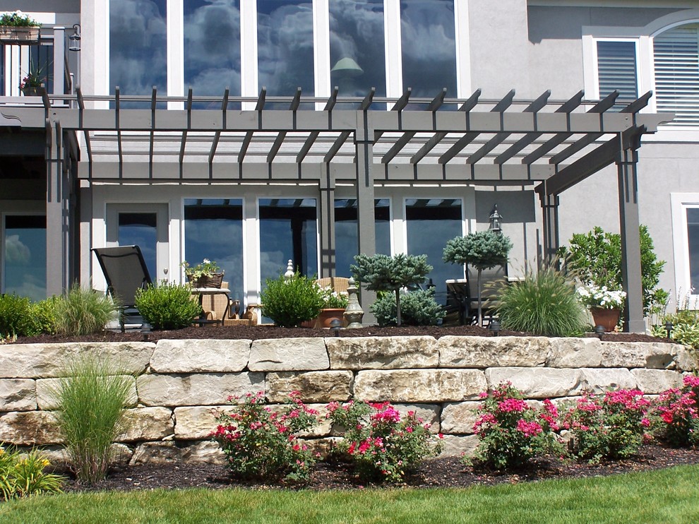 Inspiration for a medium sized classic back partial sun garden in Kansas City with a retaining wall and natural stone paving.