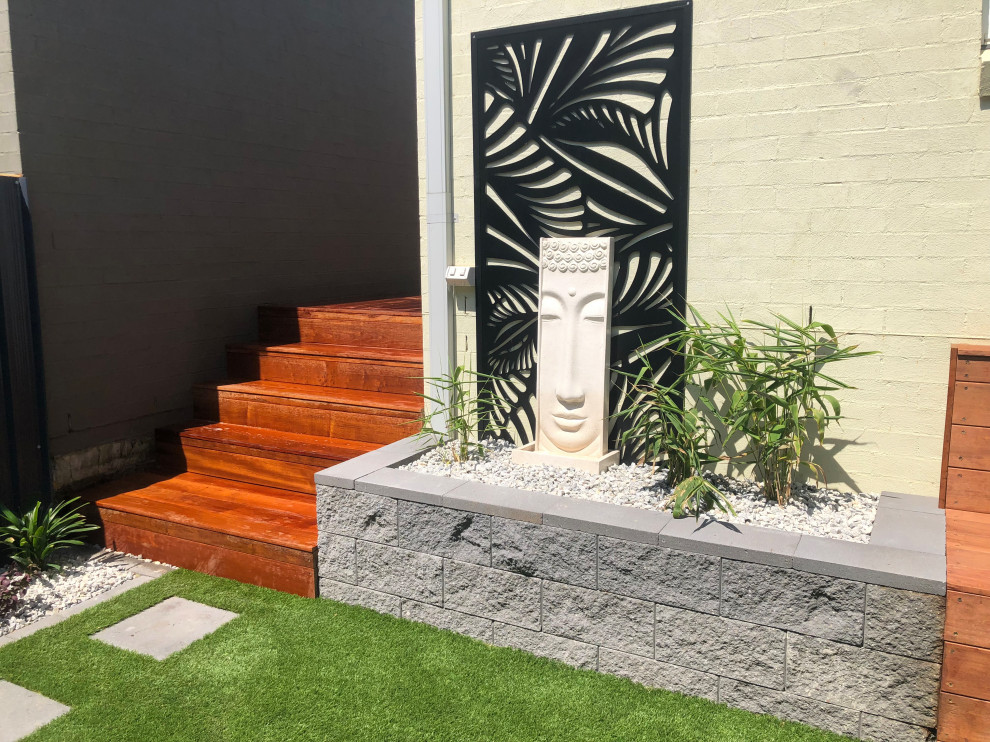 Photo of a small contemporary courtyard xeriscape in Sydney with with raised garden bed and decking.