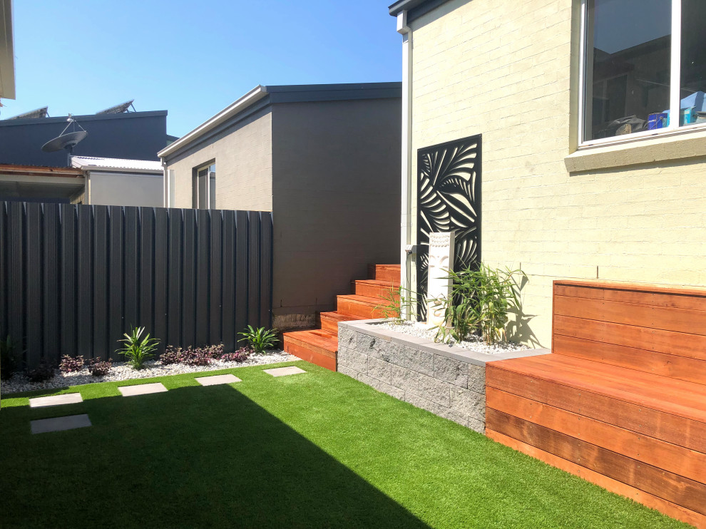 На фото: маленький засухоустойчивый сад на внутреннем дворе в современном стиле с высокими грядками, полуденной тенью и настилом для на участке и в саду с
