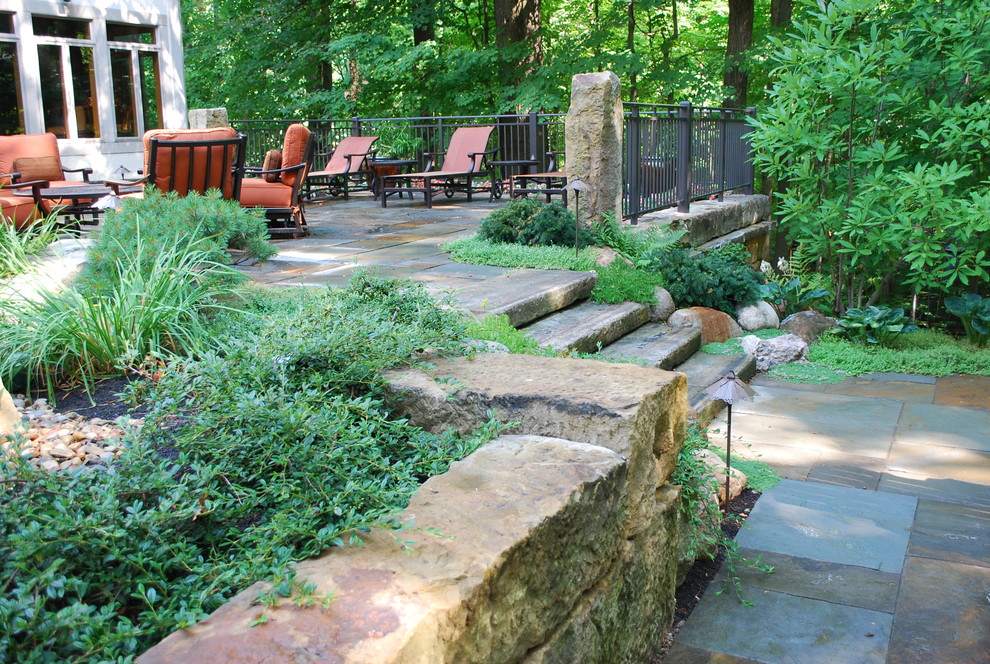 Idee per un grande giardino classico in ombra dietro casa in primavera con un muro di contenimento e pavimentazioni in pietra naturale