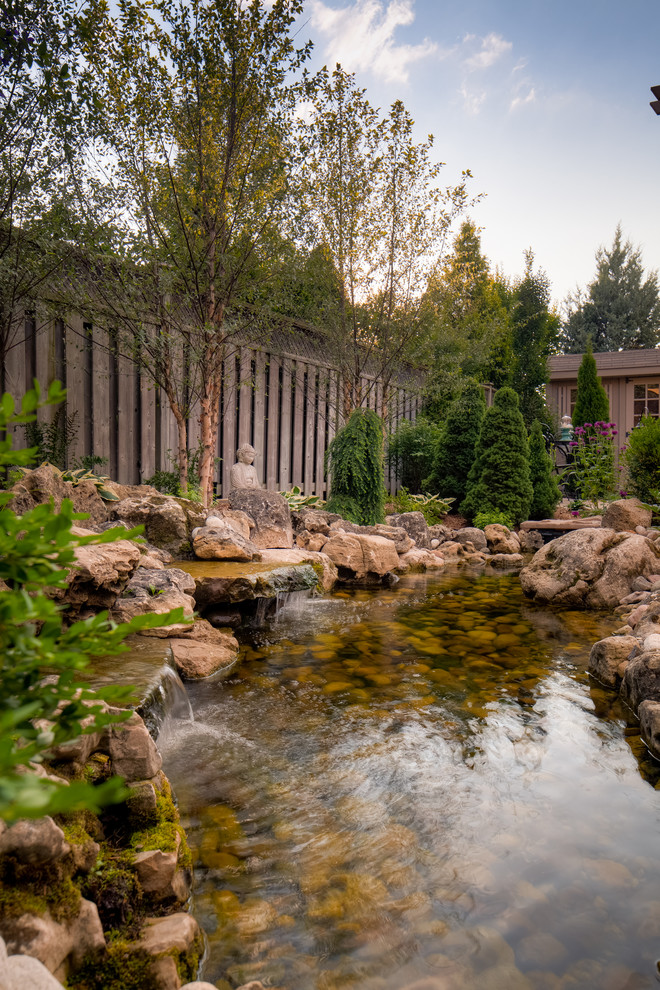Inspiration pour un jardin arrière design de taille moyenne et au printemps avec un bassin, une exposition ombragée et des pavés en pierre naturelle.
