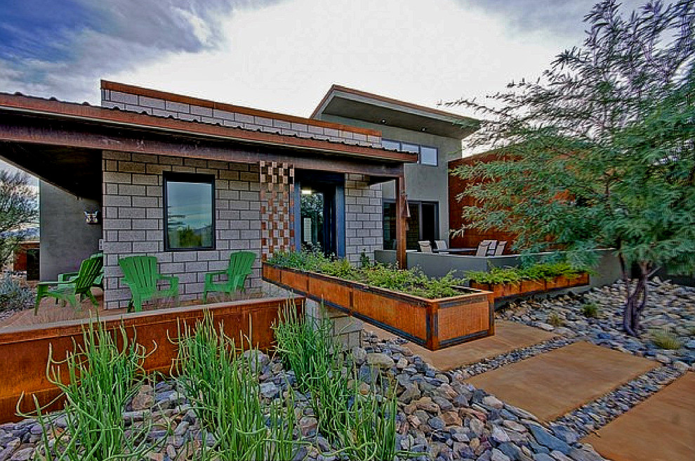 This is an example of a small contemporary drought-tolerant and full sun front yard concrete paver landscaping in Phoenix.