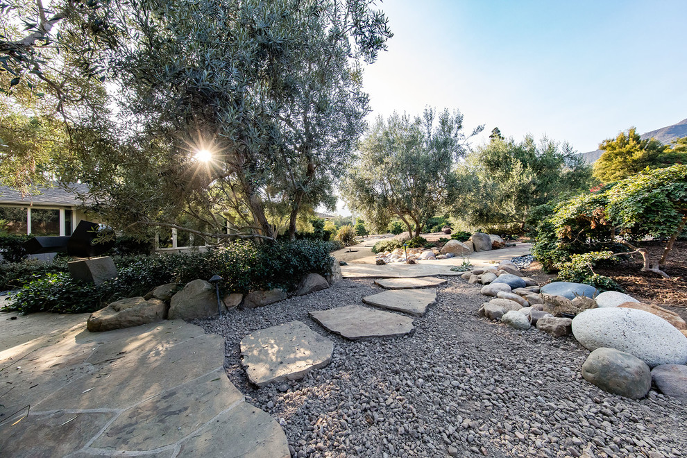 Esempio di un giardino xeriscape mediterraneo con pavimentazioni in pietra naturale