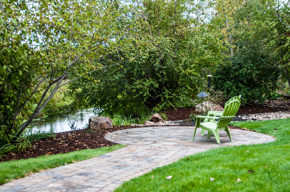 Photo of a medium sized contemporary back partial sun garden for spring in Boise with a garden path and natural stone paving.