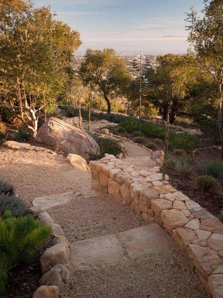 На фото: засухоустойчивый сад на переднем дворе в средиземноморском стиле с покрытием из каменной брусчатки с