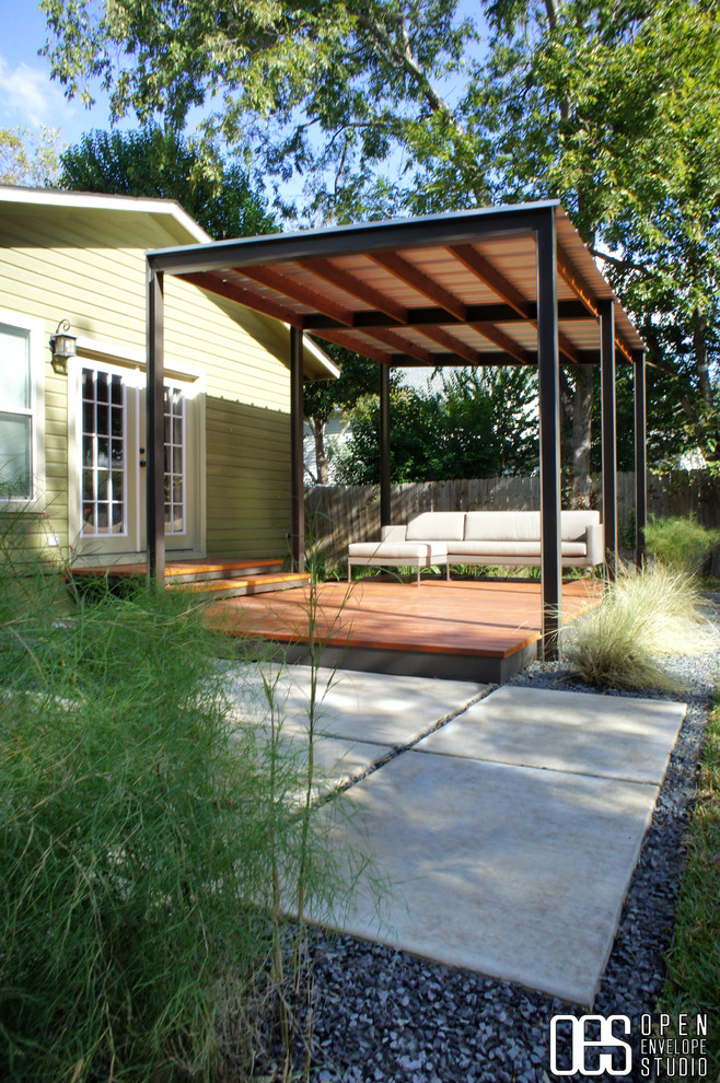 This is an example of a medium sized modern back partial sun garden in Austin with decking.