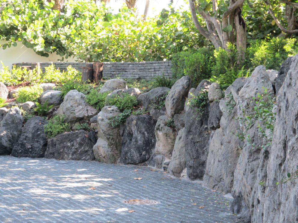 Inspiration för en mellanstor orientalisk uppfart framför huset, med en stödmur och naturstensplattor