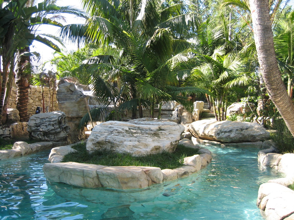 Ispirazione per un giardino tropicale esposto in pieno sole di medie dimensioni e dietro casa con pavimentazioni in pietra naturale