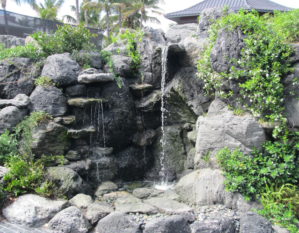 Imagen de jardín asiático de tamaño medio en patio delantero con fuente y adoquines de piedra natural