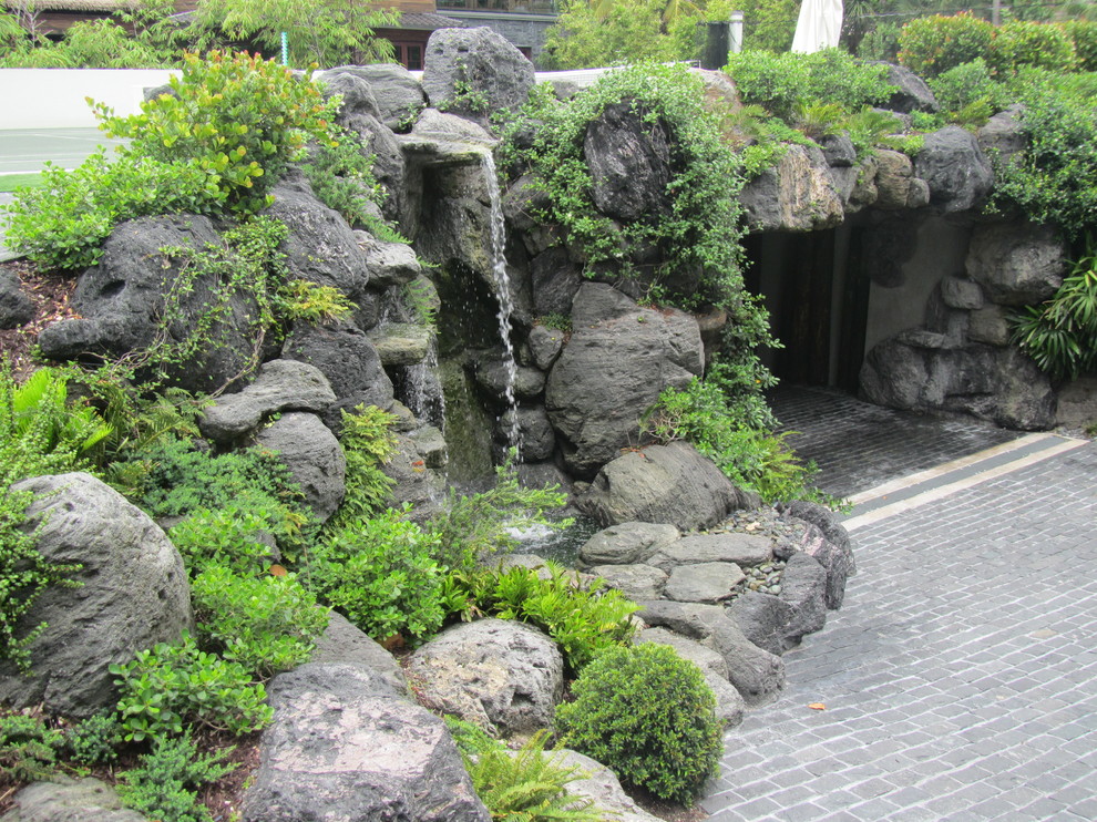 Idee per un giardino etnico esposto in pieno sole davanti casa e di medie dimensioni con fontane e pavimentazioni in pietra naturale