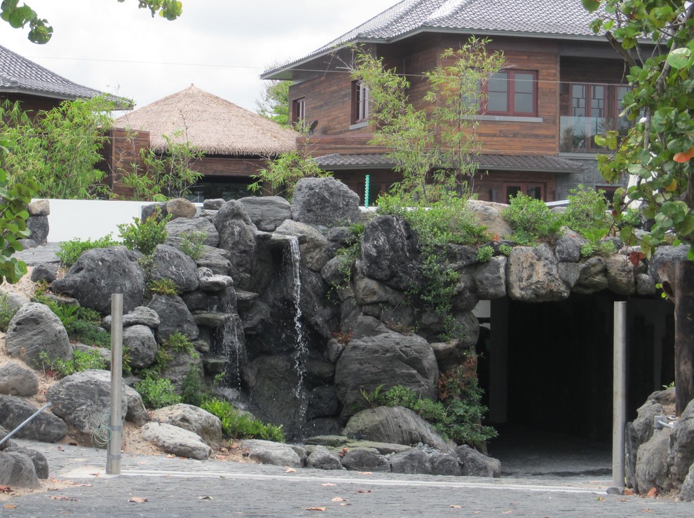 Imagen de jardín asiático de tamaño medio en patio delantero con adoquines de piedra natural y fuente
