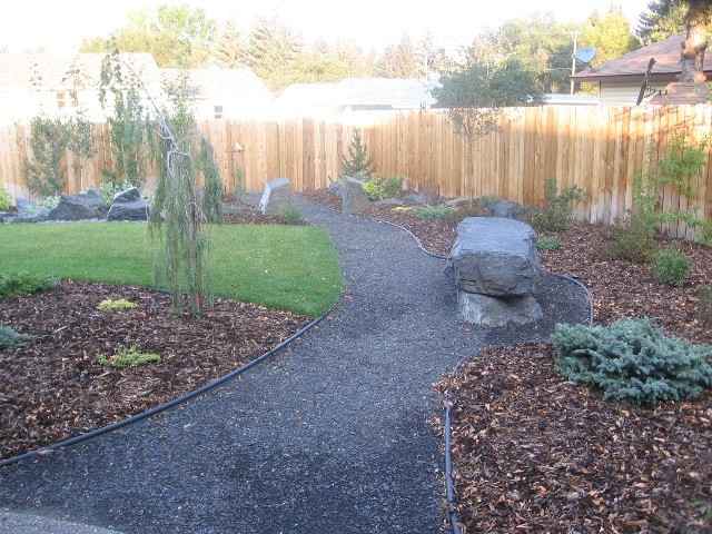 Пример оригинального дизайна: солнечный участок и сад среднего размера на заднем дворе в стиле рустика с садовой дорожкой или калиткой, хорошей освещенностью и покрытием из гравия