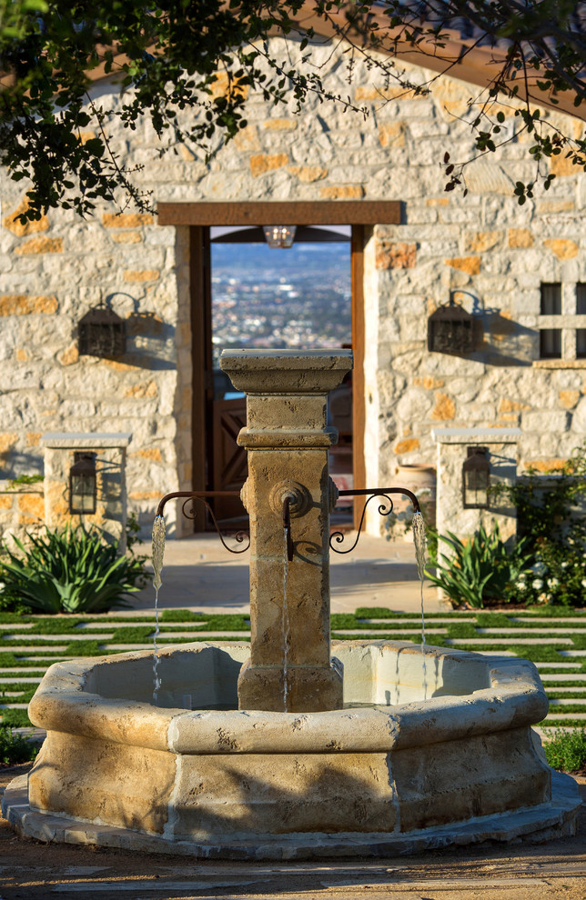 Ejemplo de jardín mediterráneo con fuente y exposición reducida al sol