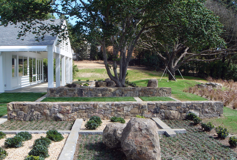 Modelo de jardín contemporáneo de tamaño medio en patio trasero con muro de contención y exposición total al sol