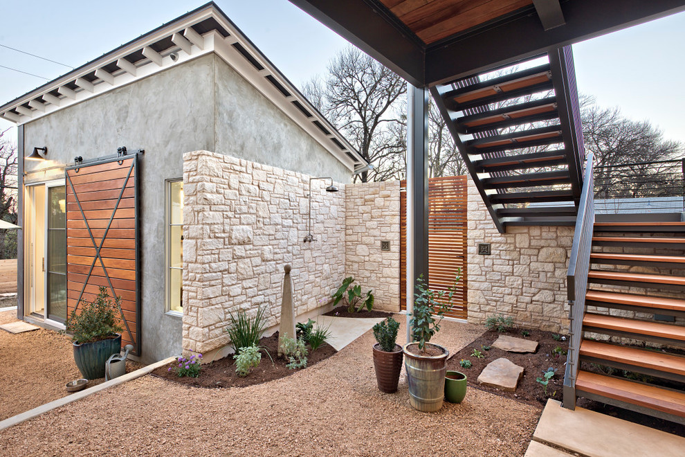 Photo of a large farmhouse courtyard xeriscape partial sun garden steps in Austin with gravel.