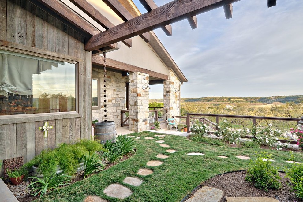 Inspiration for a large rural back garden in Austin with a potted garden and natural stone paving.