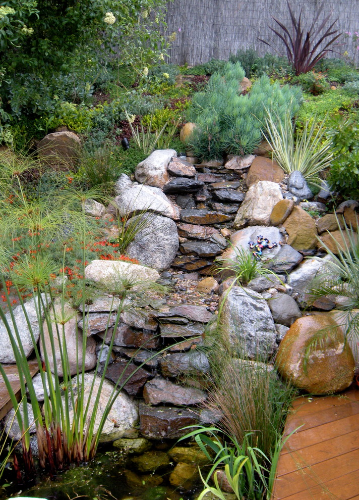 Design ideas for a mid-sized eclectic partial sun backyard water fountain landscape in Los Angeles with decking.