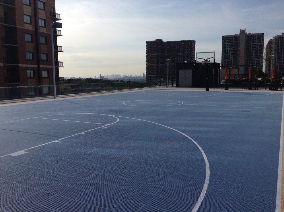 Immagine di un grande campo sportivo esterno moderno esposto a mezz'ombra sul tetto con uno spazio giochi