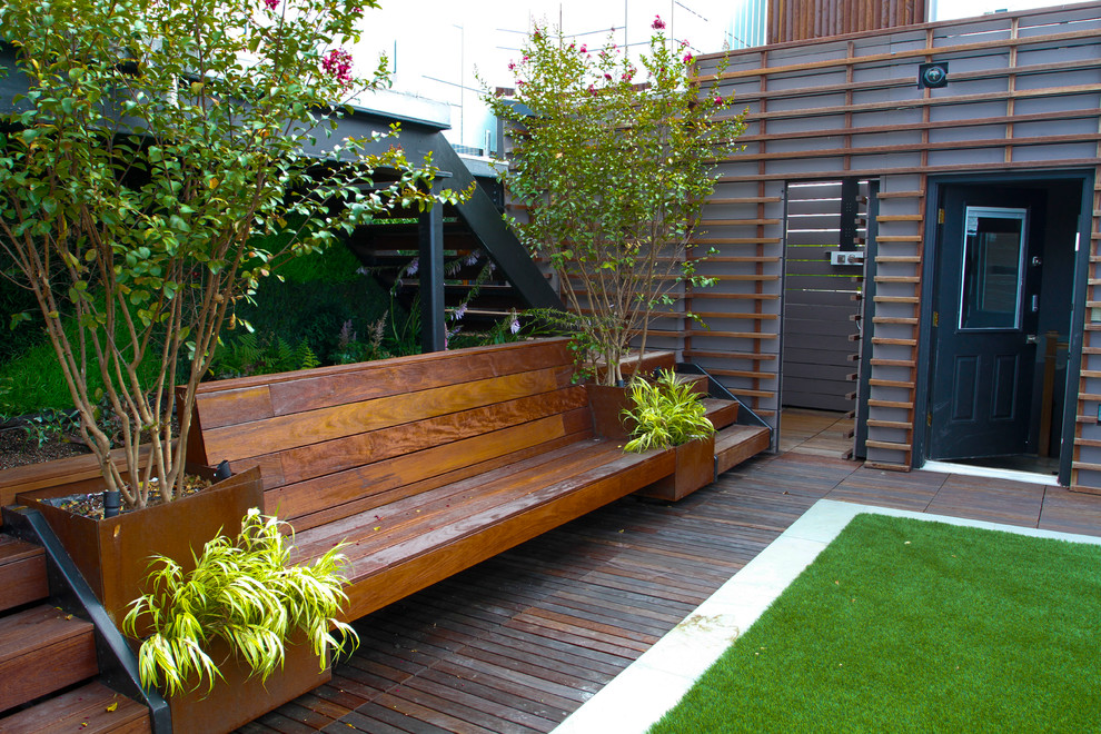 This is an example of a large modern partial sun rooftop landscaping in New York with a fire pit for summer.