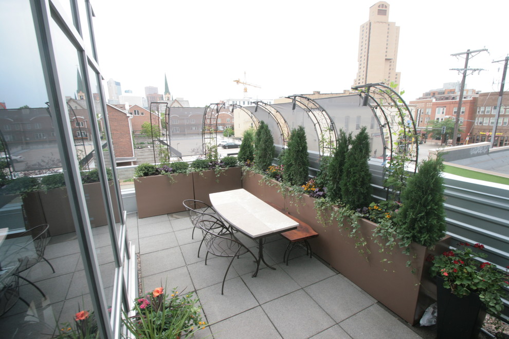 Пример оригинального дизайна: маленький солнечный, летний регулярный сад на крыше в стиле фьюжн с растениями в контейнерах, хорошей освещенностью и мощением тротуарной плиткой для на участке и в саду