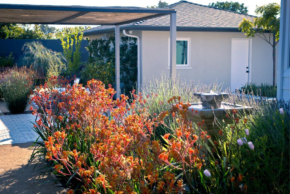 Mittelgroßer Garten hinter dem Haus mit Wasserspiel, direkter Sonneneinstrahlung und Granitsplitt in Los Angeles