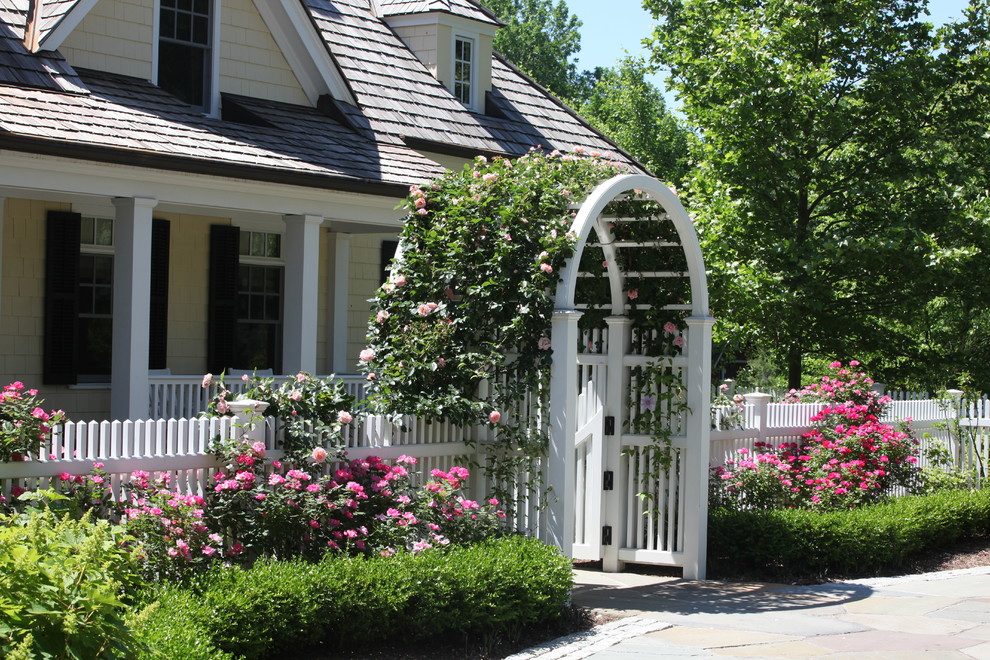 This is an example of a large classic back formal full sun garden in New York with a garden path and natural stone paving.