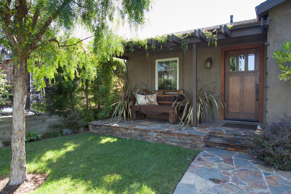 Photo of a mid-sized contemporary partial sun front yard stone landscaping in Los Angeles.