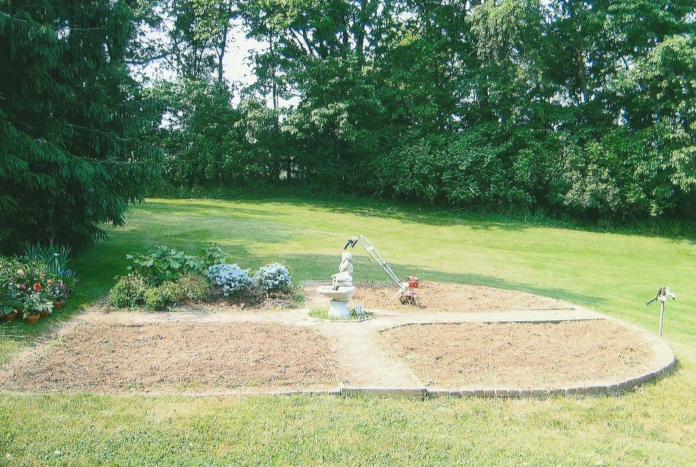 Design ideas for a large classic side formal full sun garden for summer in Other with a garden path and mulch.