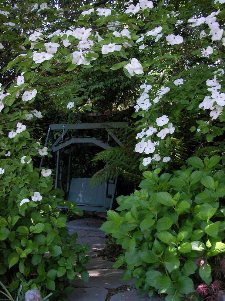 Ejemplo de jardín clásico de tamaño medio en patio trasero con camino de entrada y adoquines de piedra natural