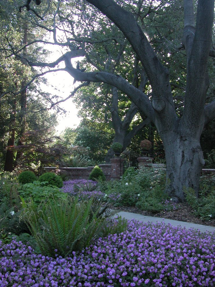 Modelo de jardín tradicional de tamaño medio en patio delantero con jardín francés, camino de entrada y adoquines de piedra natural